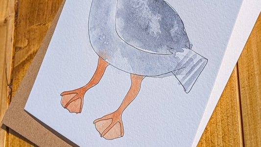 Illustration of a bird on a card with a wooden surface background.