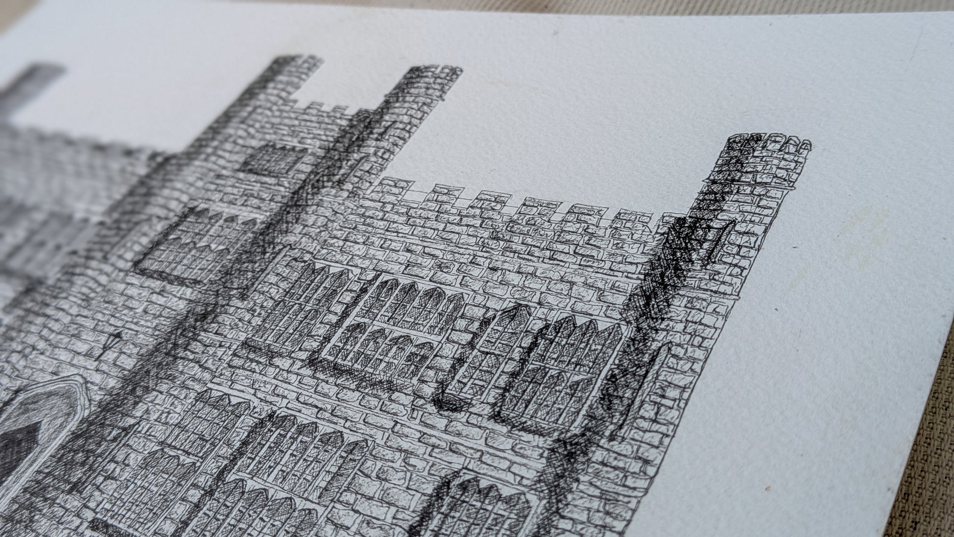Detailed black and white line drawing of a stone building on a textured surface